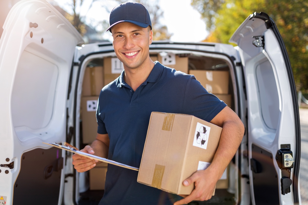 Delivery driver unloaded a box from the back of a van. 