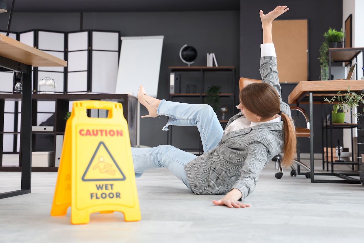 Office worker falling on a wet floor during a slip-and-fall accident in a workplace setting