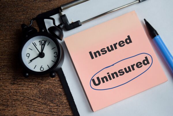Sticky notes on a wooden table displaying the word “uninsured” inside a blue circle, representing uninsured driver accidents and auto insurance coverage issues in Nevada.